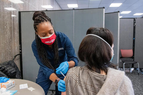 A nurse administering a COVID-19 vaccine to a patient.